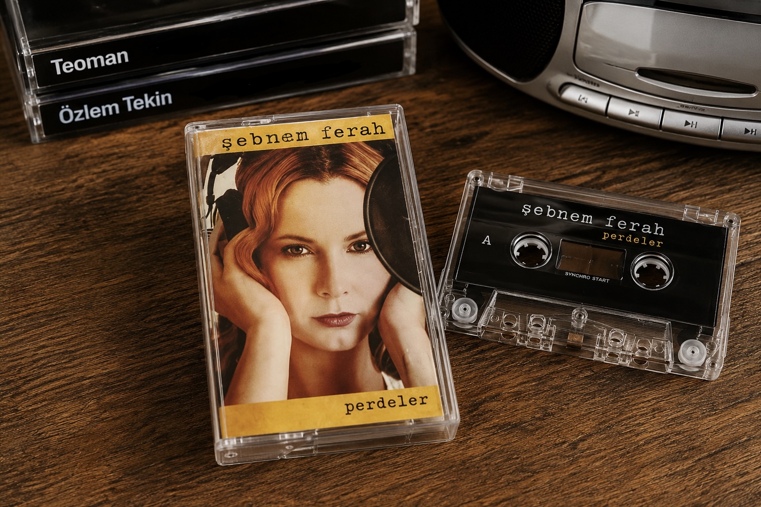 Ahşap masa üzerinde Şebnem Ferah'ın Perdeler albüm kaseti ve 2000'li yılları hatırlatan müzik seti